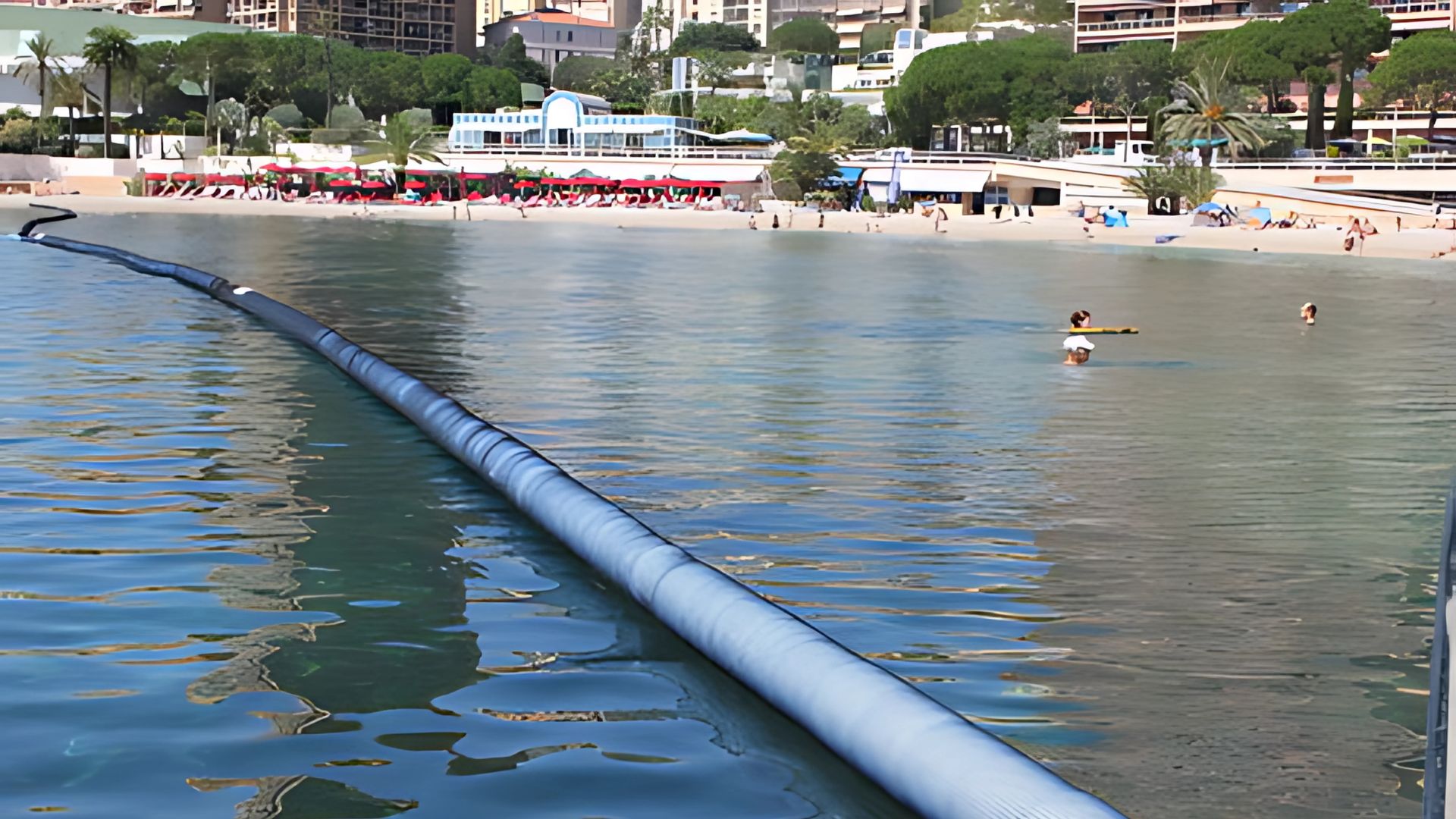 Beach safety boom deployed in a tropical resort with clear blue waters