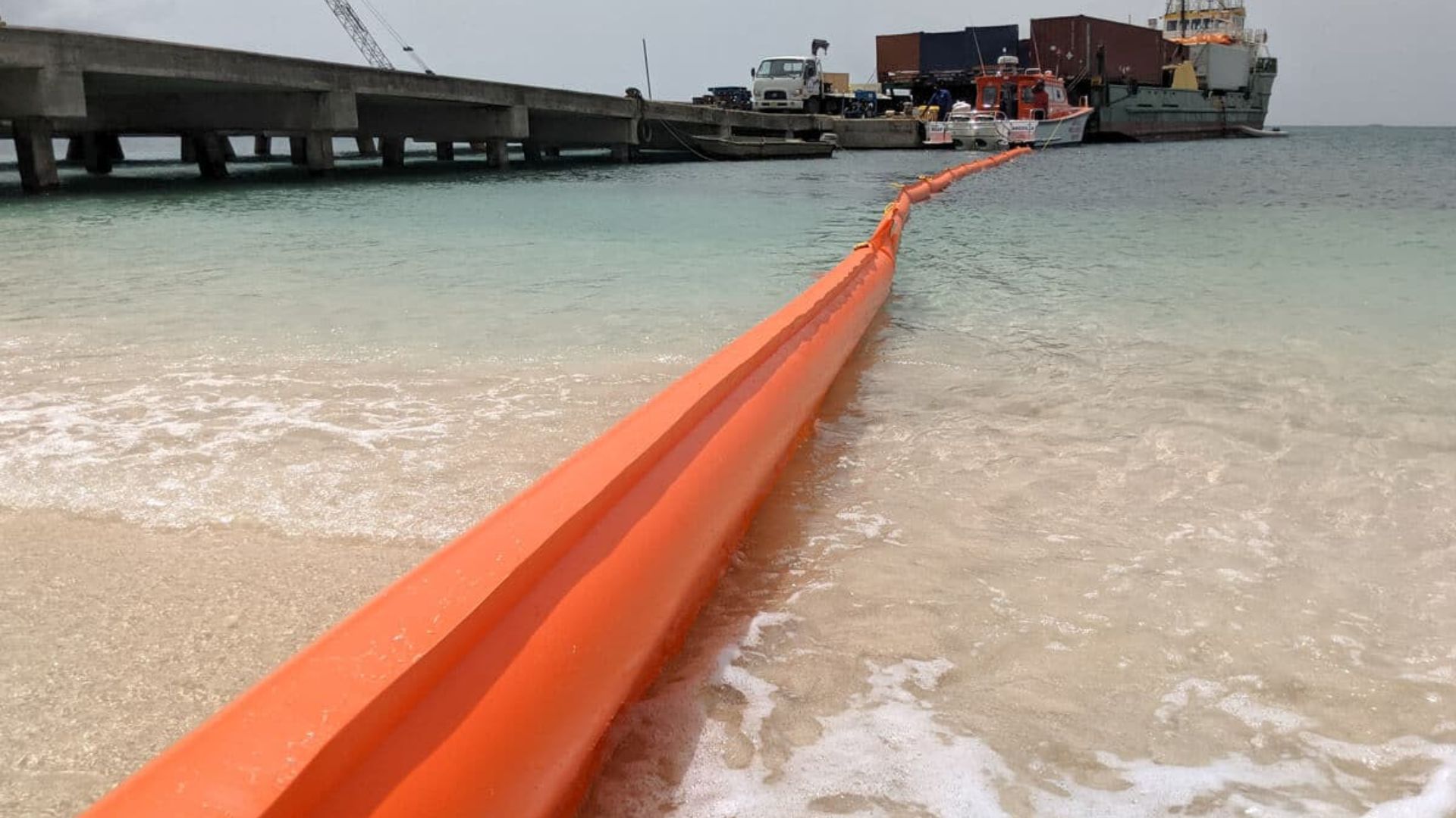 Floating safety barrier marking a designated swimming zone in open sea.